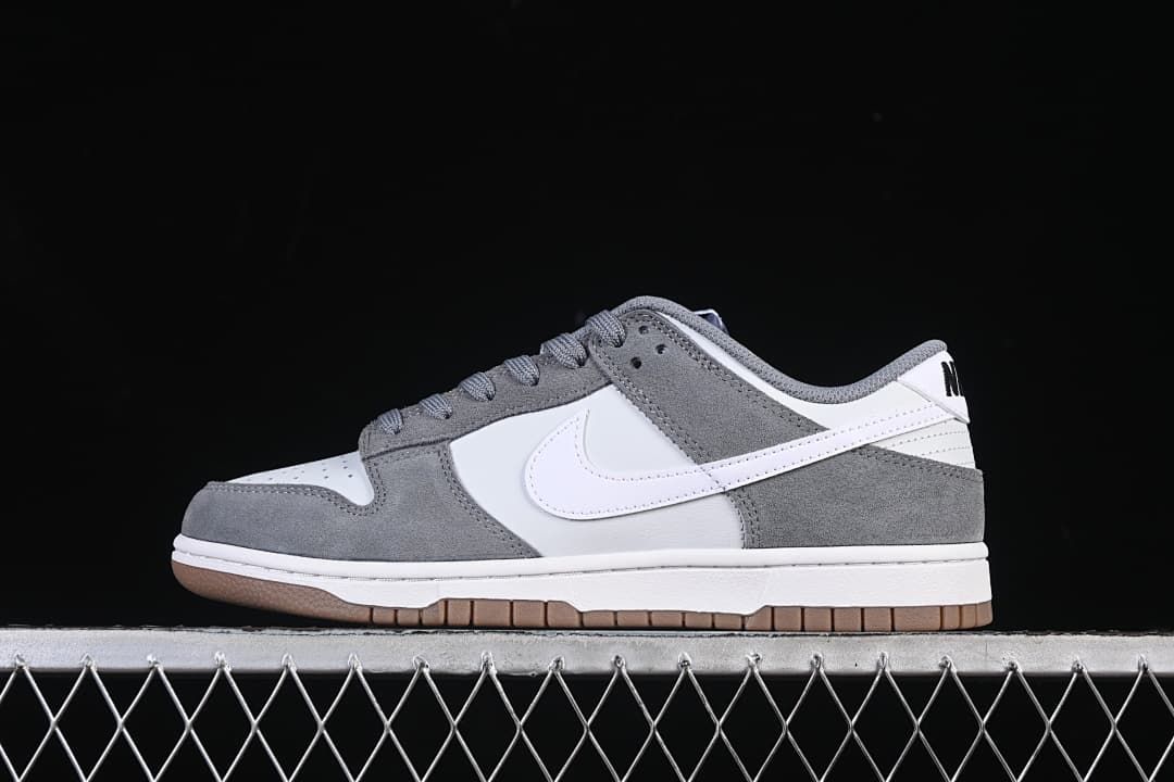 Side view of white and grey Nike SB Dunk Low shoes with a gum-colored outsole