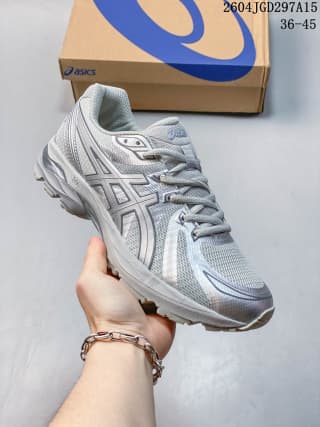 White and gray ASICS sneaker with mesh-style panels, side branding, and a layered outsole.