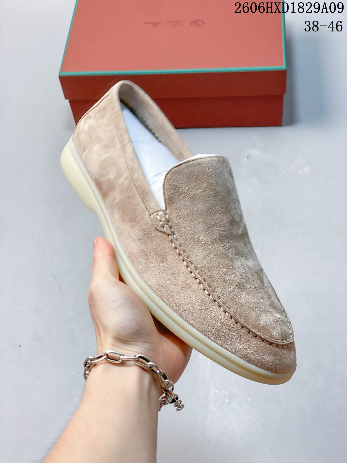 Angled view of a beige loafer with moc-toe stitching