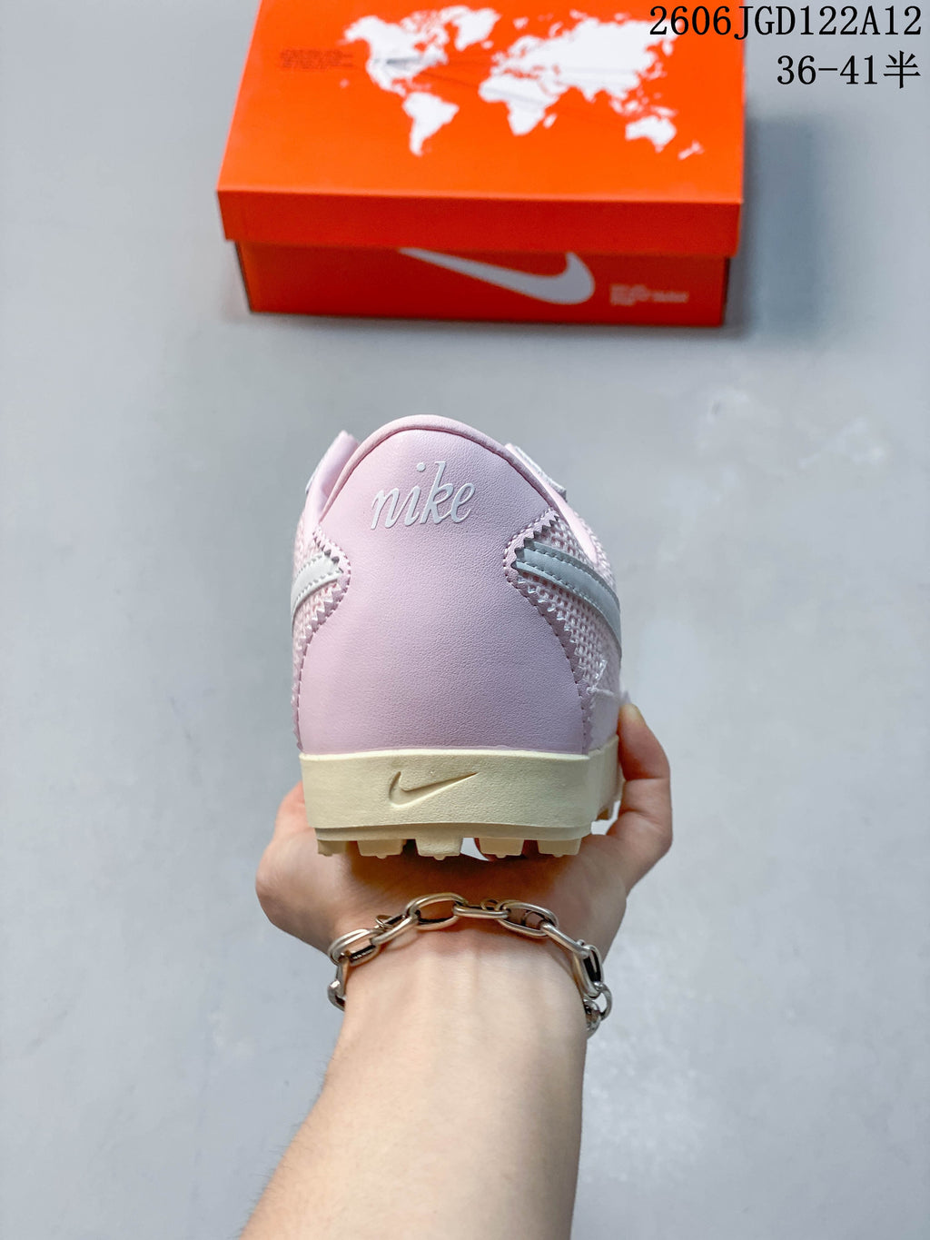 Rear view of the pink sneaker with Nike branding and cream-colored sole