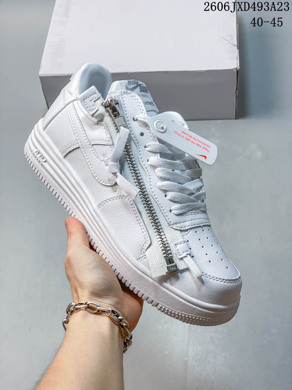 Angled view of the white low-top sneaker with laces and side zipper