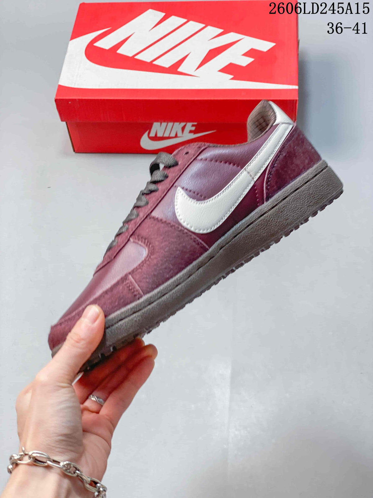 Side view of the burgundy low-top sneaker with a light-colored side panel and textured outsole.