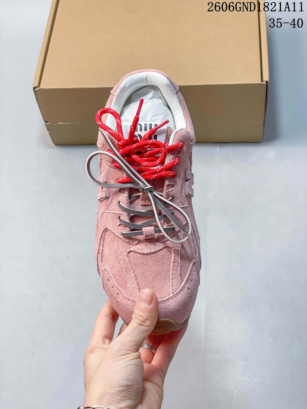 Top view showing the pink upper and red, gray, and cream laces