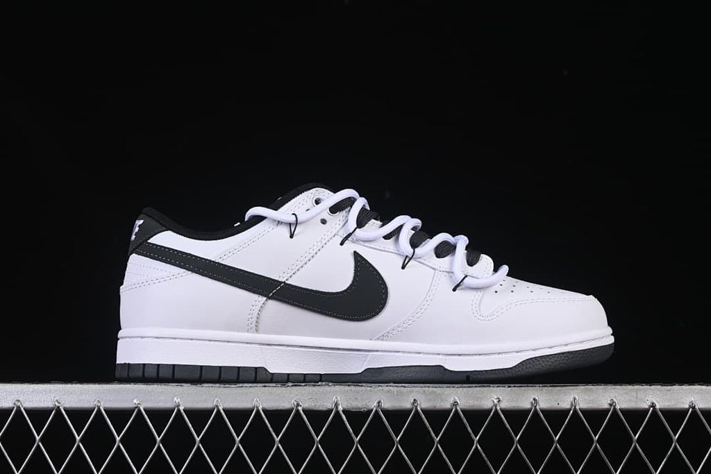 Side profile of a white sneaker with black Swoosh and sole details