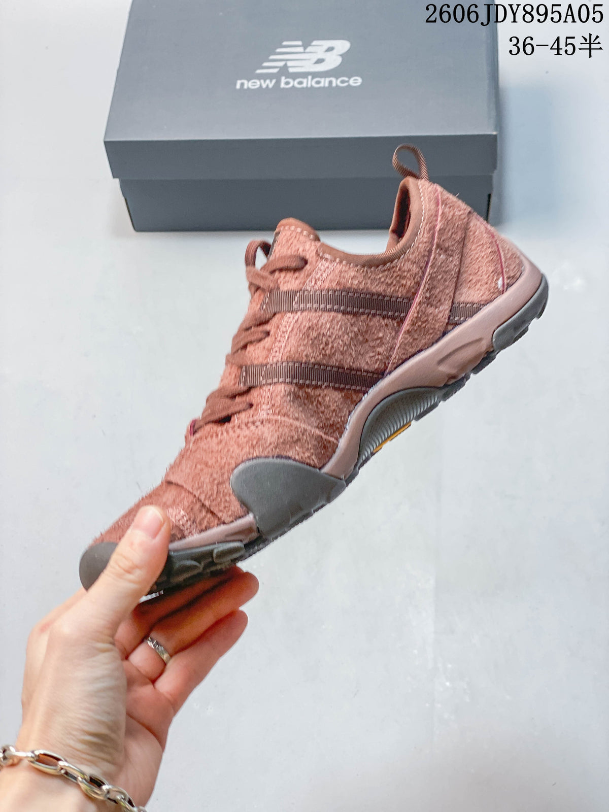 Side profile of a dusty rose low-top sneaker with layered panels and lugged sole