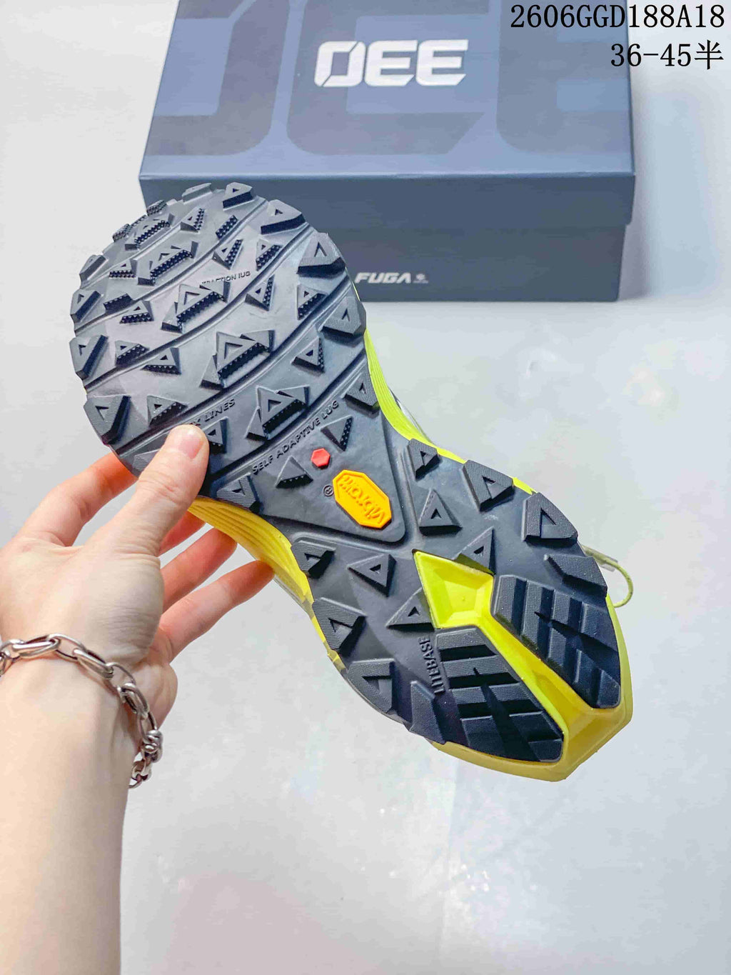 Close-up of the shoe's lugged outsole, with the box in the background; image text shows style code 2606GGD188A18 and size range 36–45.5.