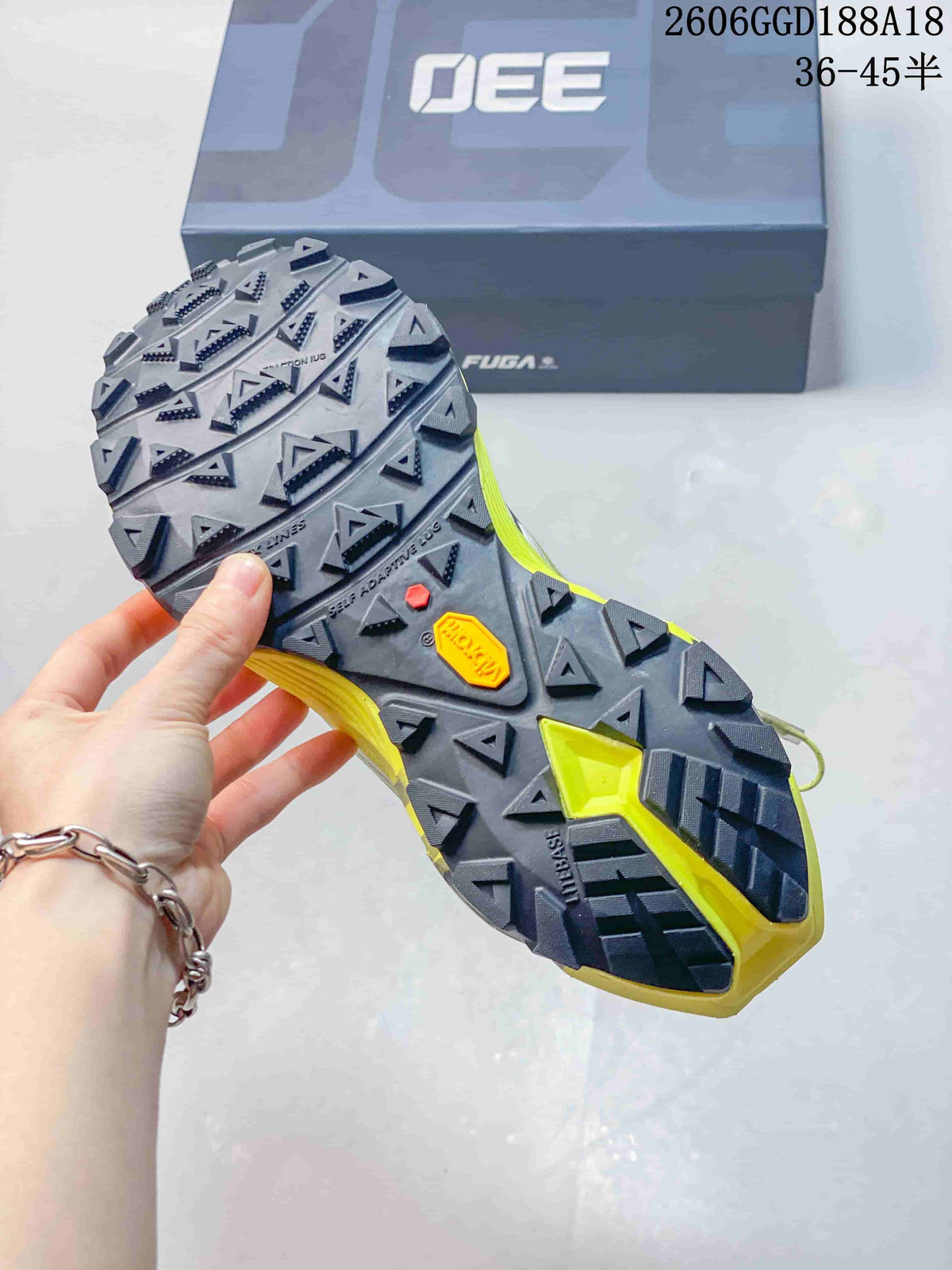 Close-up of the shoe's lugged outsole, with the box in the background; image text shows style code 2606GGD188A18 and size range 36–45.5.