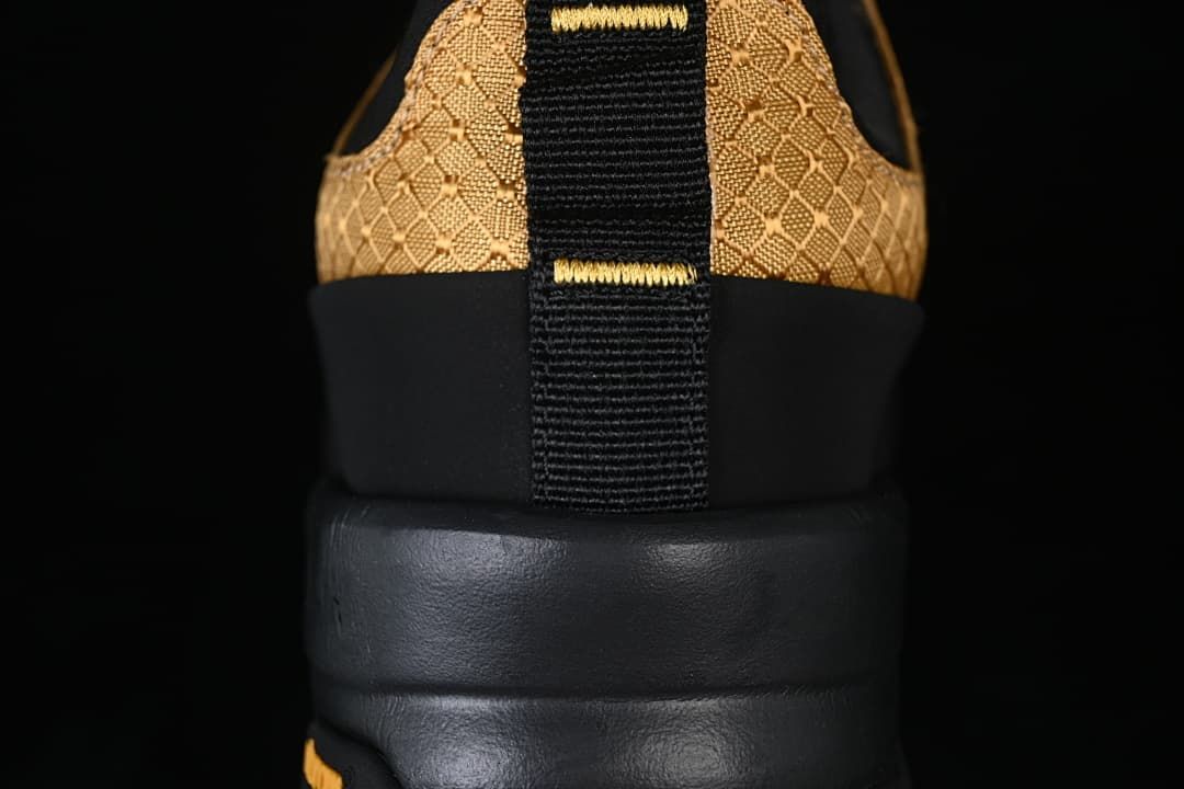 Rear view showing the gold patterned heel, black pull tab and sole