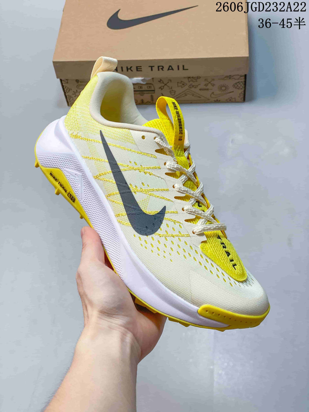 Side view of a light Nike Wildhorse 10 trail-running shoe with yellow accents and a trail-style outsole.