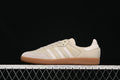 Side view of beige adidas Samba OG sneakers with light stripes and a gum-look sole.