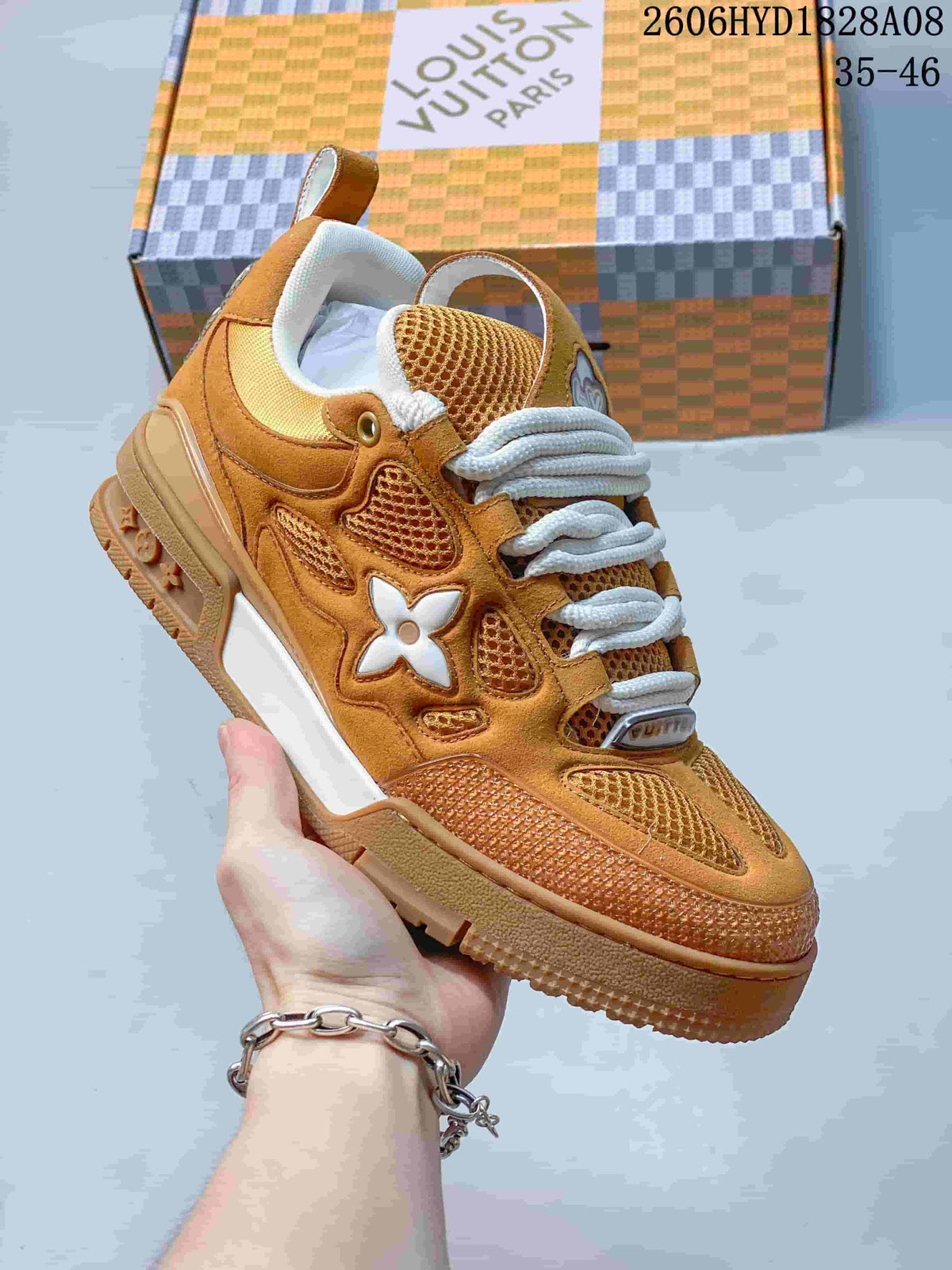 Angled side view of the brown sneaker with mesh panels, white laces and a white side accent