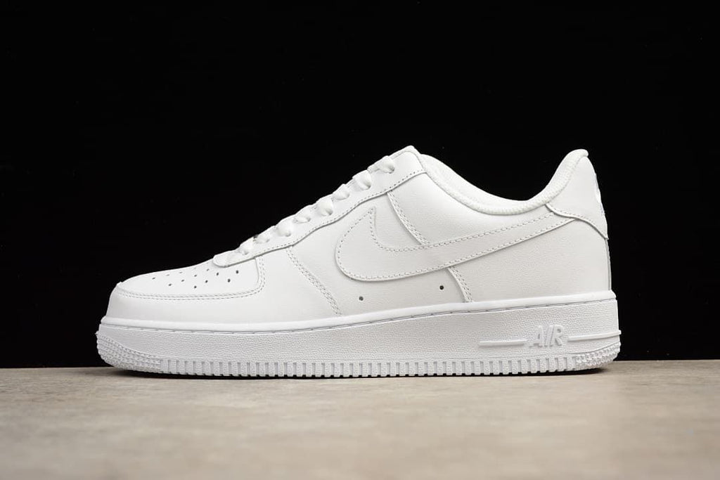 White low-top sneaker shown in side profile against a black background.