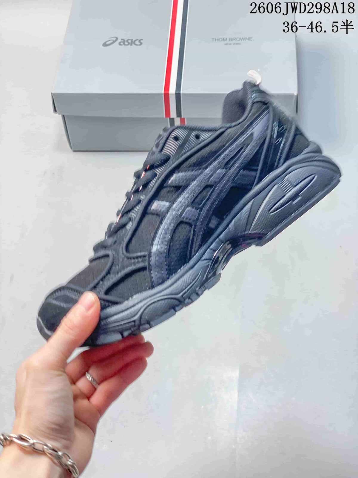 Side profile of the dark gray sneaker showing layered panels and sculpted sole