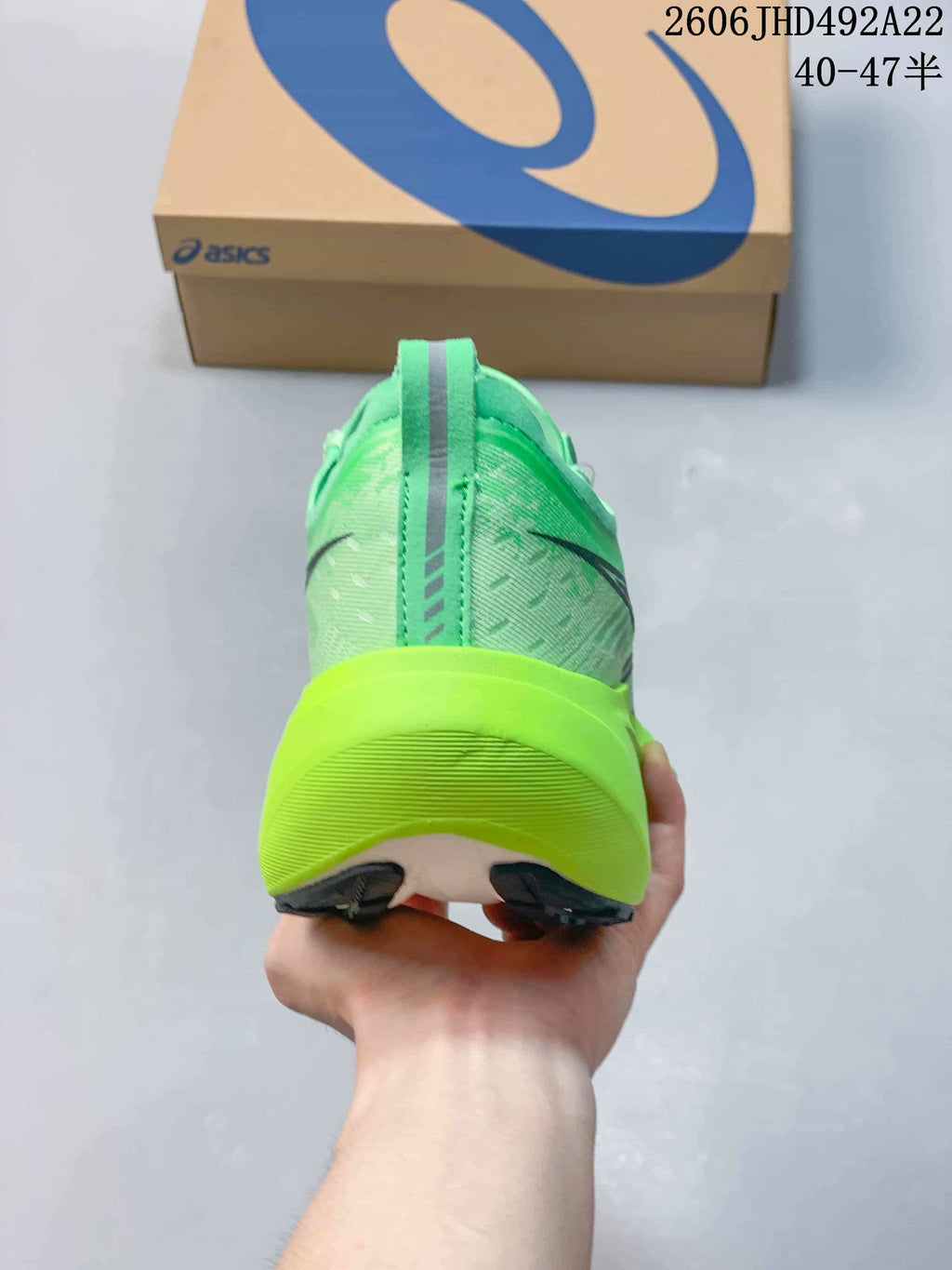 Rear view of a green running shoe with a vivid lime-colored heel midsole
