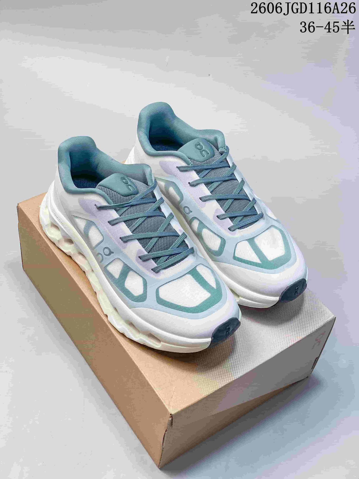 Pair of white On Cloudtilt Remix sneakers with teal accents, shown on a shoebox.