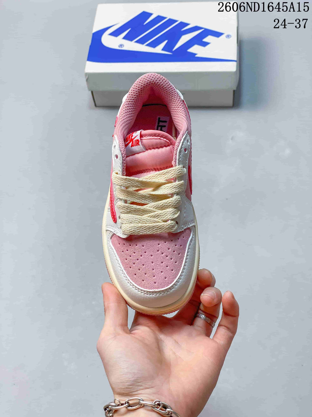 Top view highlighting the perforated pink toe, white overlays, and cream-colored laces.