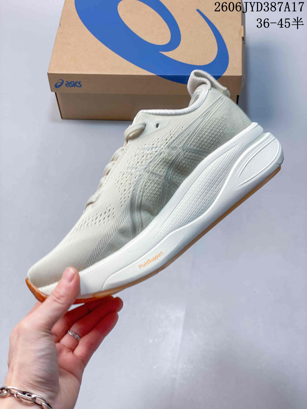 Side view of the light-colored running shoe with lace-up closure and visible FluidSupport marking