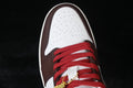 Close-up of the white perforated toe, dark brown overlays, and red laces