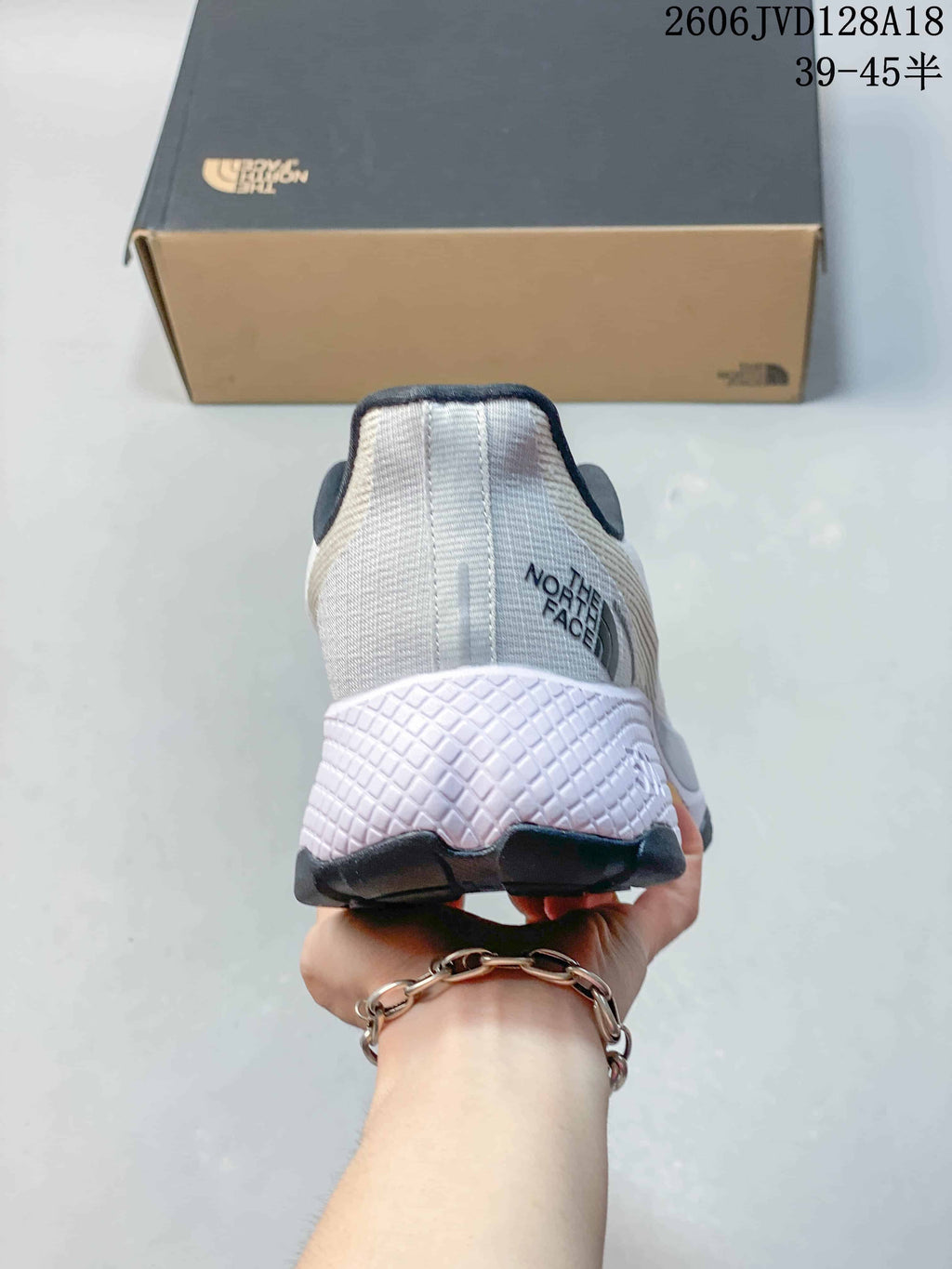 Rear view showing the heel and sculpted midsole of a white The North Face running shoe.