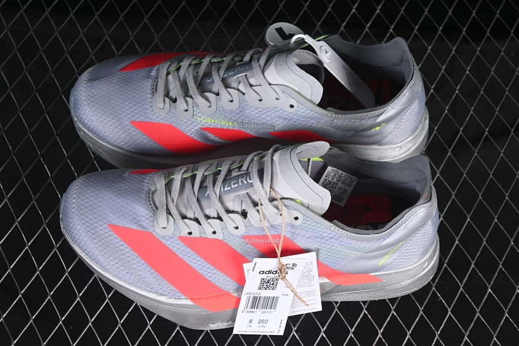 Pair of gray and coral Adizero running shoes displayed together