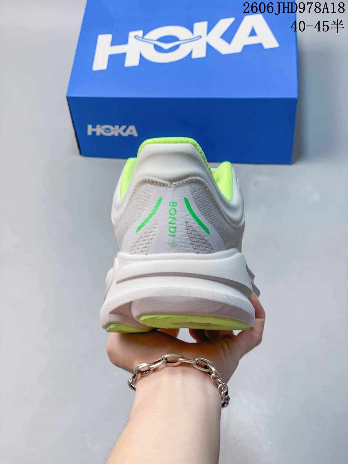 Rear view of a white Bondi 9 shoe with neon-green collar lining