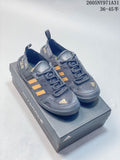 Pair of dark gray adidas Terrex outdoor shoes with yellow-orange stripes, shown on a shoebox