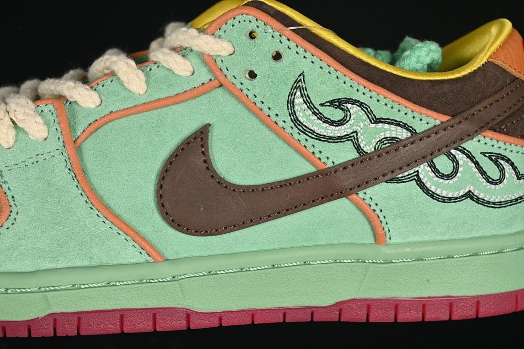 Close-up of the brown Swoosh and embroidered side graphics on the mint green upper.
