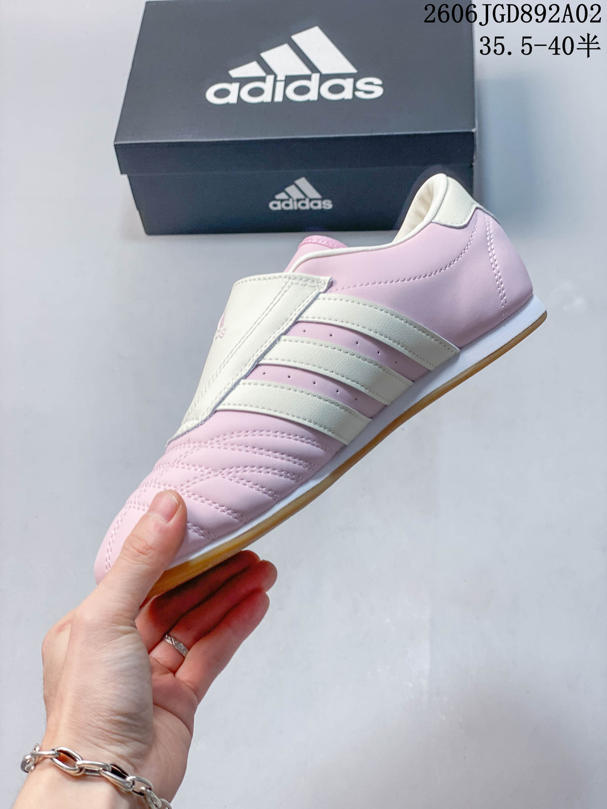 Side profile of a pink and off-white Adidas Taekwondo shoe