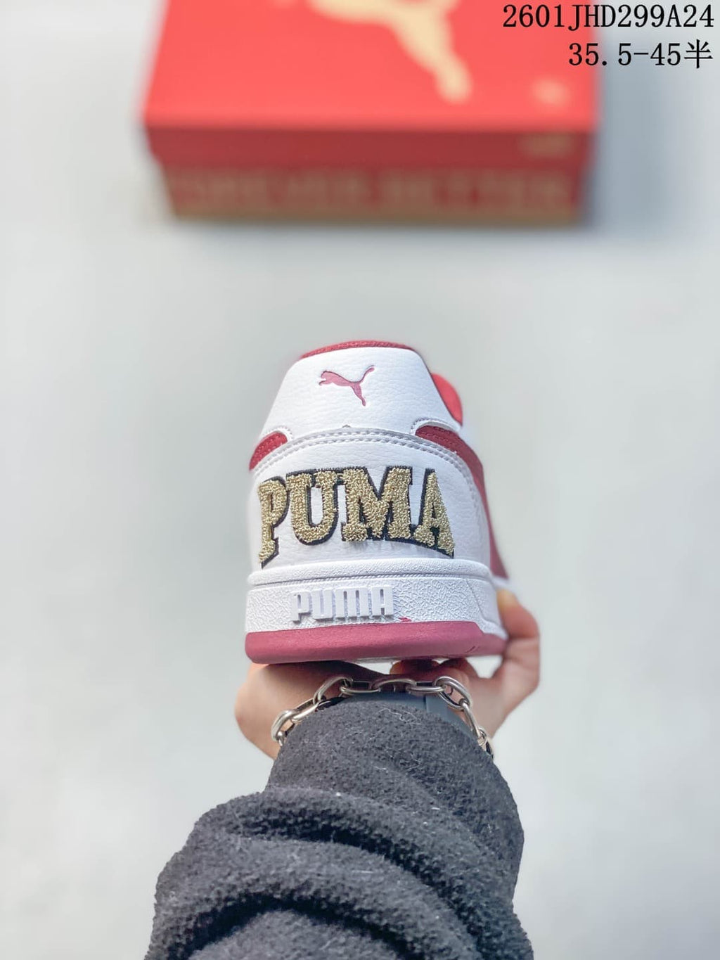 Rear view of a white Puma Caven 2.0 sneaker with red and gold-toned details