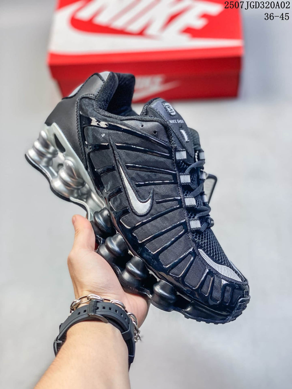Angled side view of a black and silver Nike Shox TL sneaker