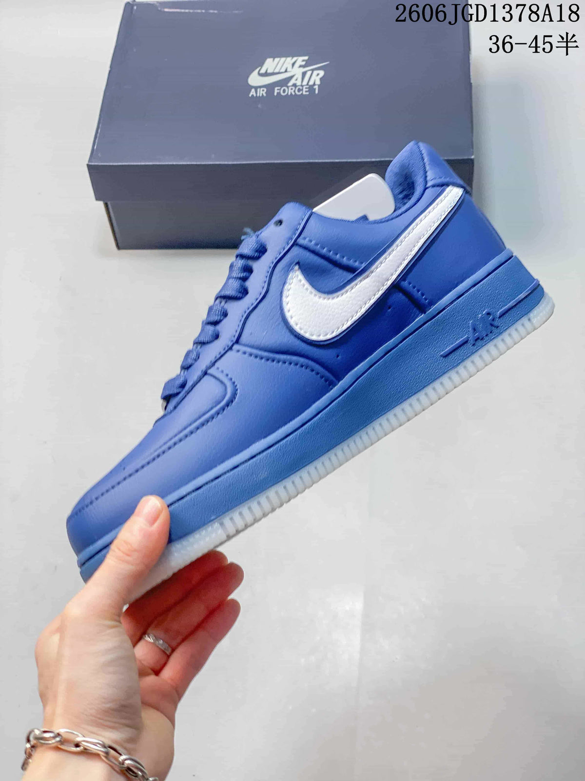 Side view of a blue low-top sneaker with a white Swoosh and white outsole