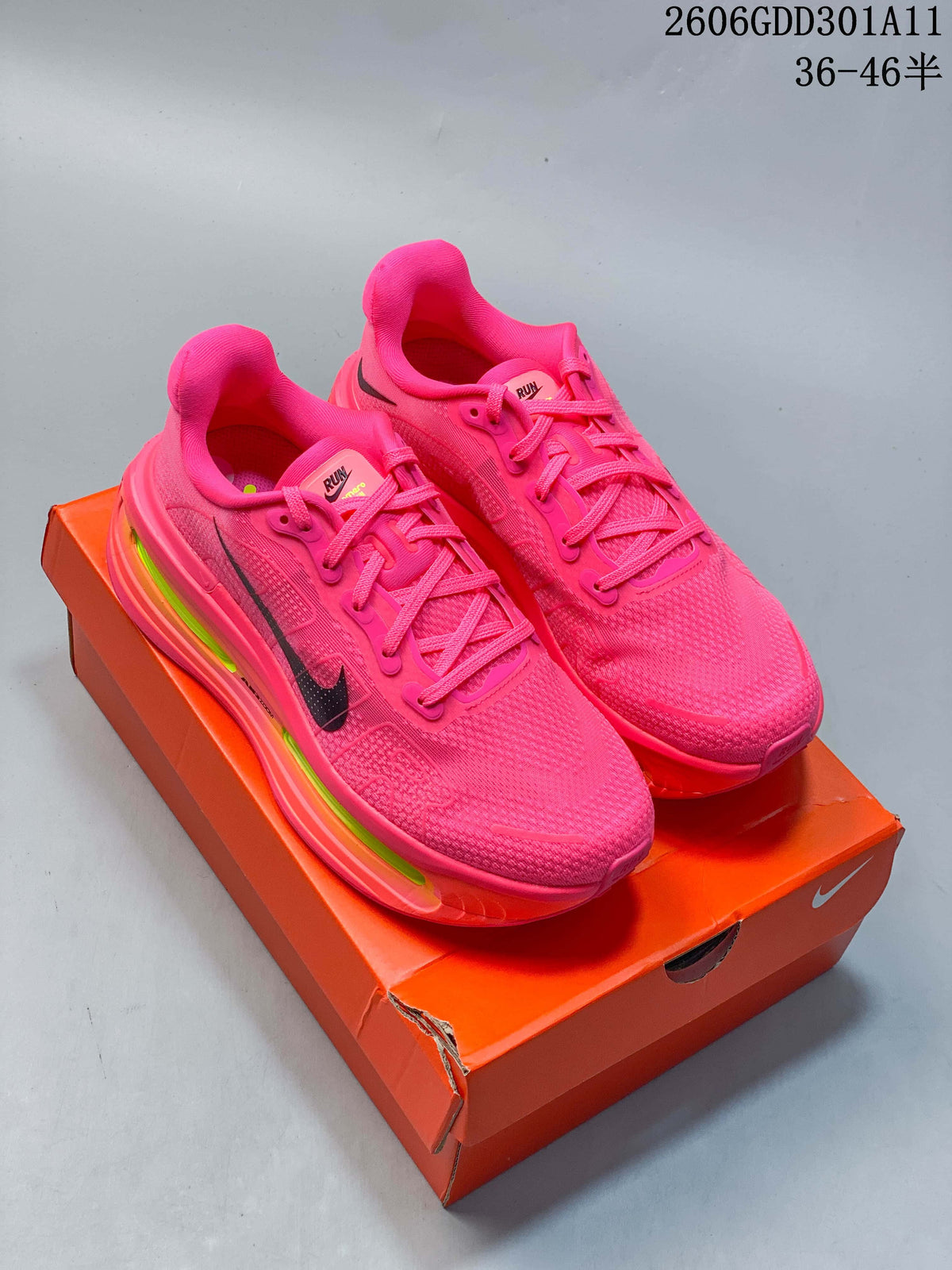 Pair of hot-pink Nike Vomero Premium running shoes with black Swoosh details and thick multicolor-accented soles, pictured on an orange shoe box.