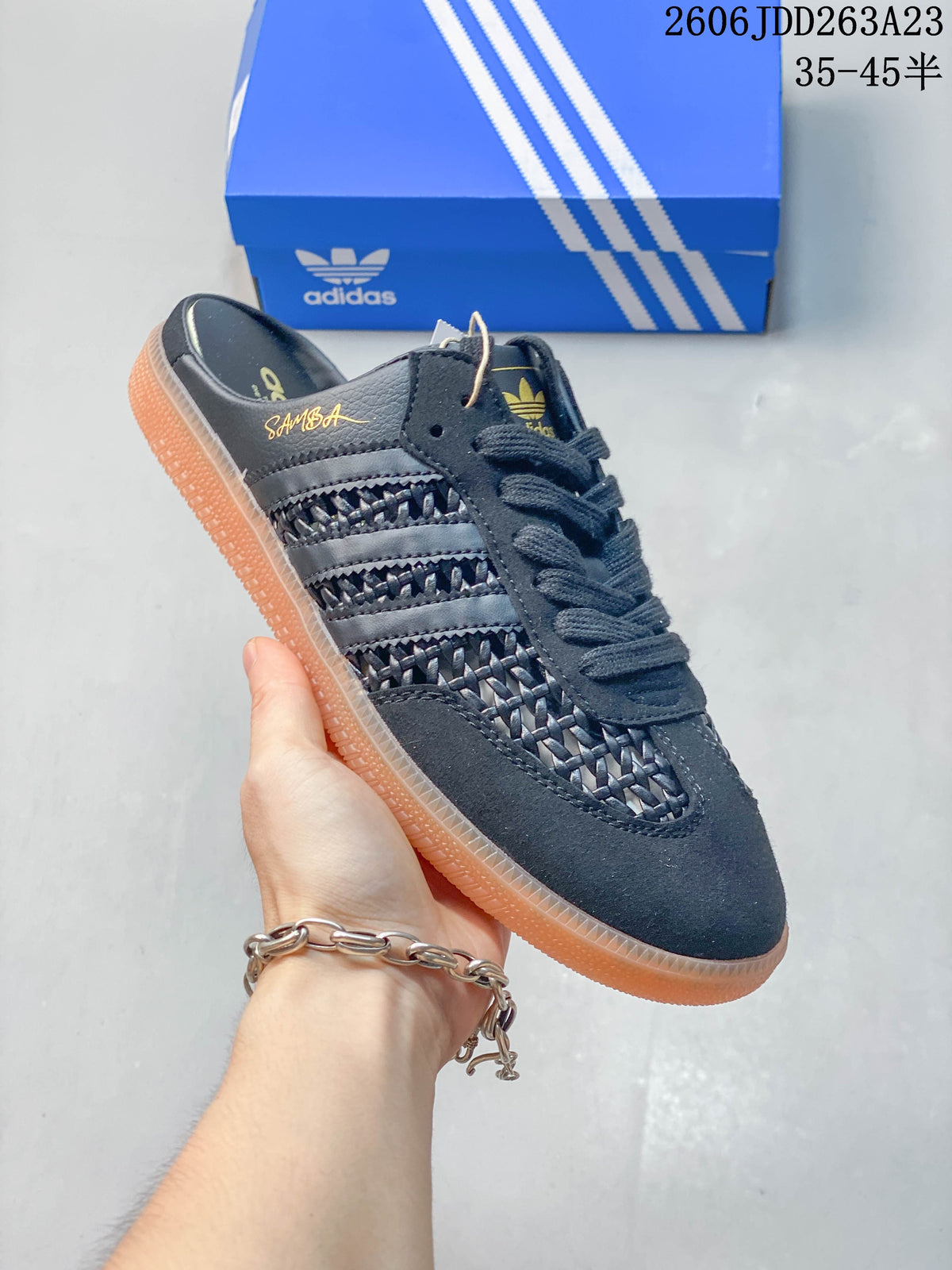 Angled view of the dark gray Samba OG Mule with its open heel and translucent gum-colored sole