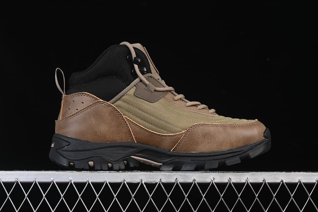 Side profile of an olive and brown mid-height lace-up boot with a black sole.