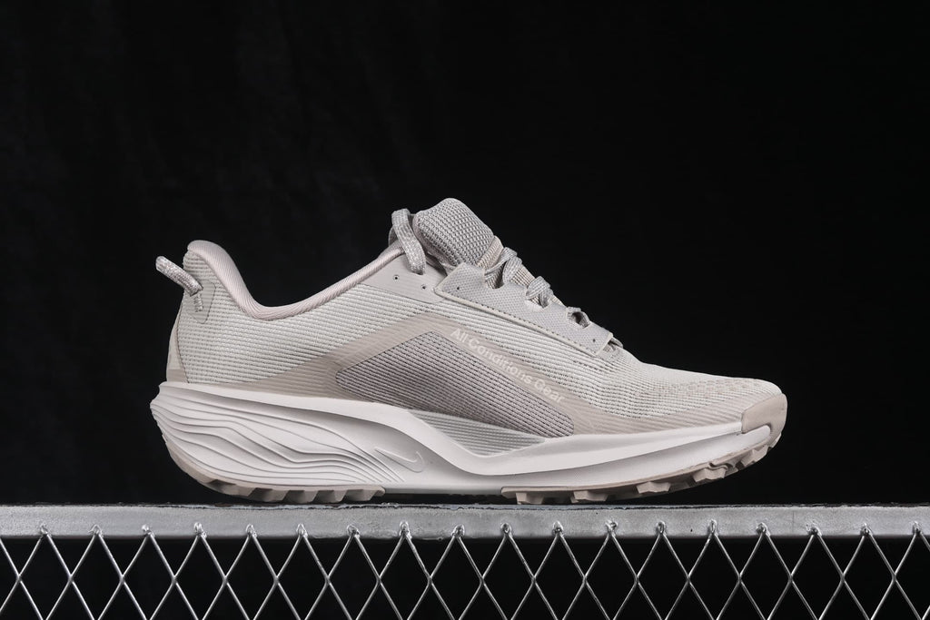 Side view showing the ACG Pegasus Trail silhouette, mesh panels, Swoosh branding, and outsole lugs.
