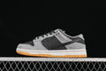 Side view of grey and black Nike SB Dunk Low sneakers with a white midsole and gum outsole