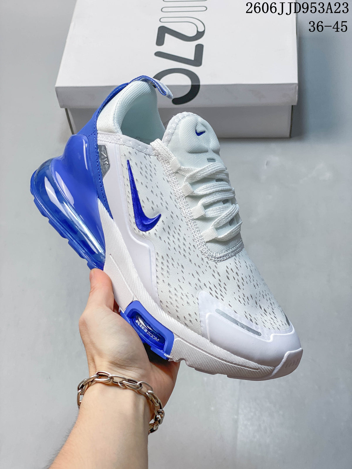 Side view of a white Nike Air Max 270 sneaker with blue accents and a visible heel air unit.
