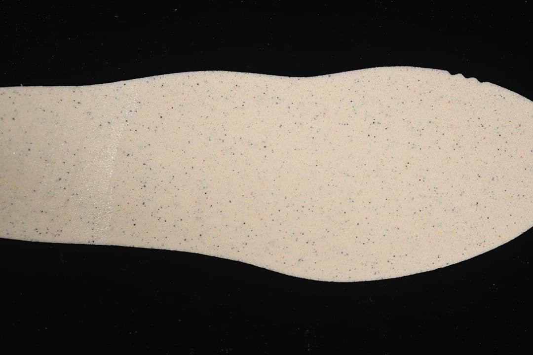 Light-colored shoe insert with small multicolor flecks