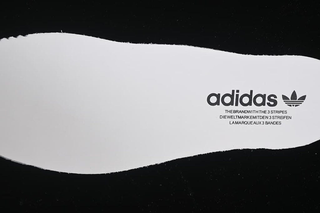 White shoe-shaped insert with adidas branding.