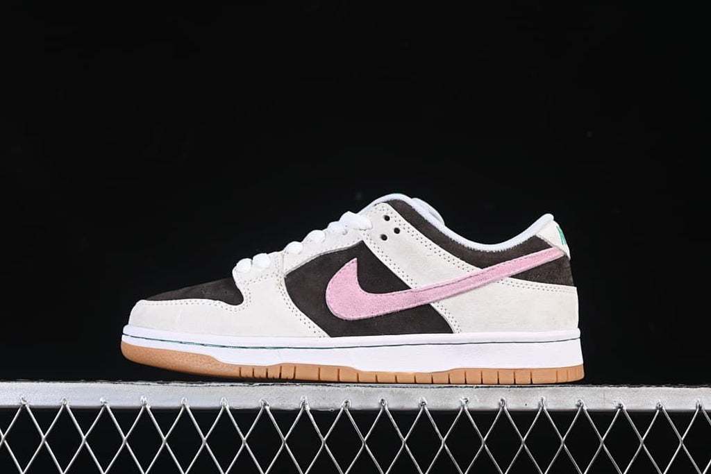 Side view of a grey, dark brown and pink Nike SB Dunk Low with a gum outsole