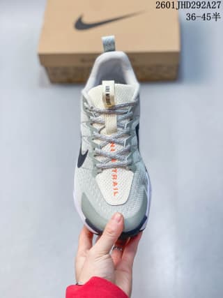 Top-down view showing the laces, padded tongue, pale green upper, dark Swoosh, and orange tongue branding.
