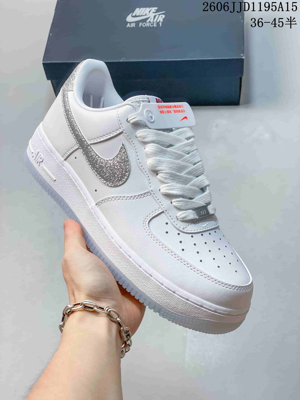 Side view of a white low-top sneaker with a silver reflective-look Swoosh and perforated toe.