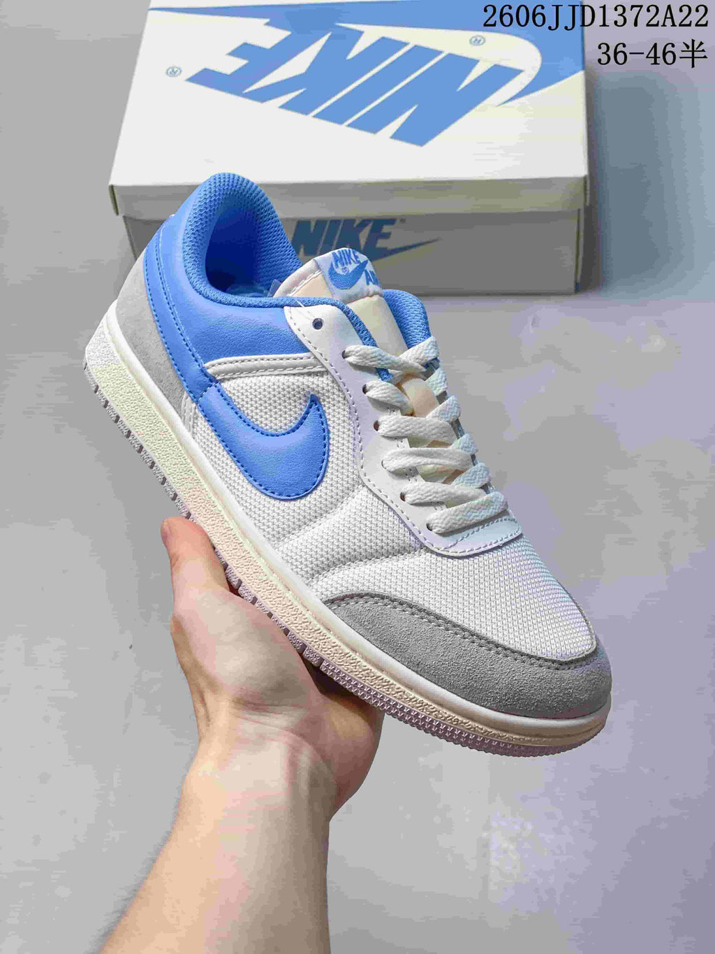 Single white and gray Nike Air Jordan Skyline sneaker with blue accents, held in hand.