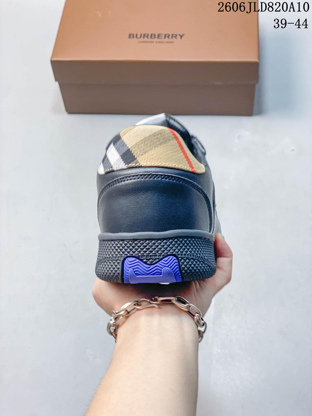 Rear view of a navy low-top sneaker with a beige check-pattern heel panel and textured outsole
