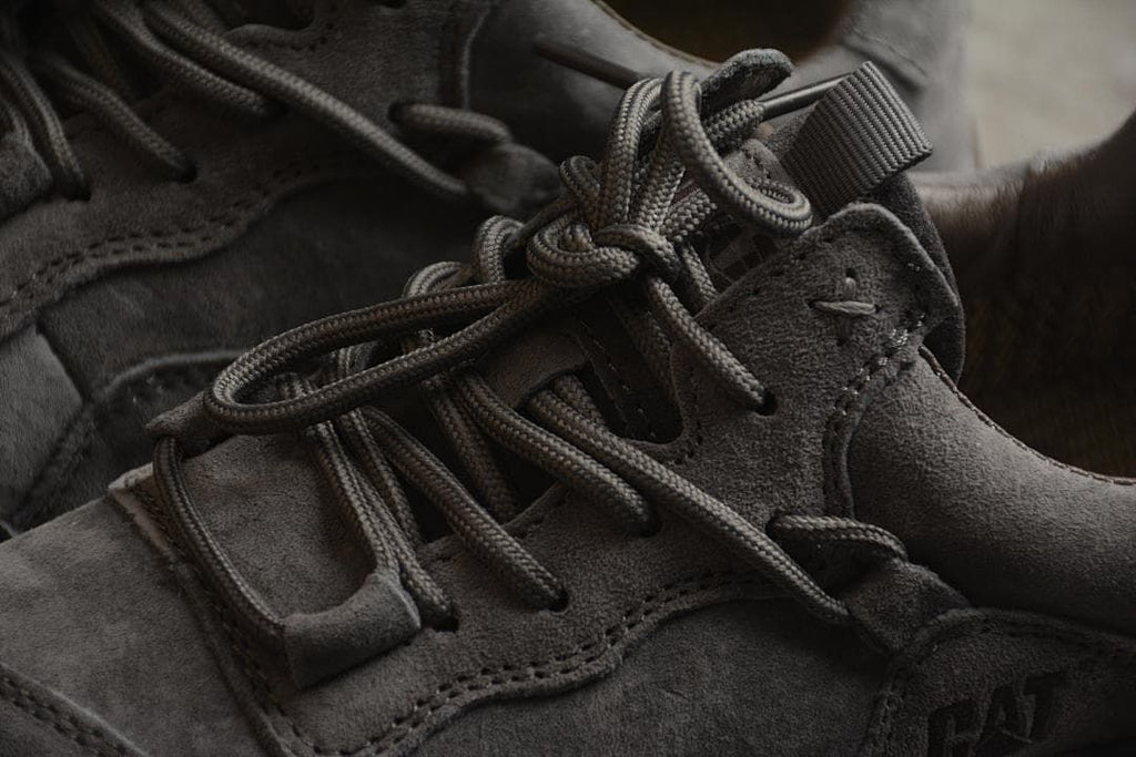 Close-up of the gray lace-up area, overlays and CAT side logo.