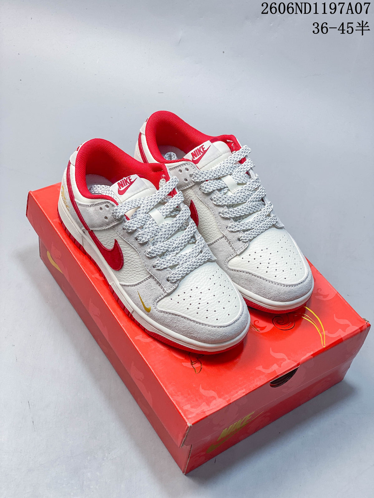 Pair of white and light gray low-top sneakers with red Swooshes, red lining, and patterned laces on a red box.