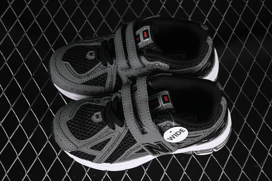 Pair of black and gray kids’ sneakers with hook-and-loop straps and a visible wide-fit tag.