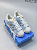 Pair of light blue Adidas Originals Campus 00s sneakers with cream shell toes, silver stripes, and white laces.