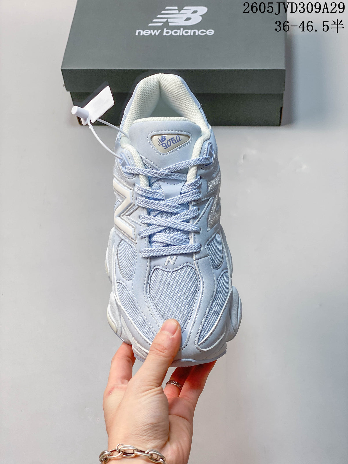 Front view of a pale blue New Balance 9060 sneaker showing its mesh toe and laces.