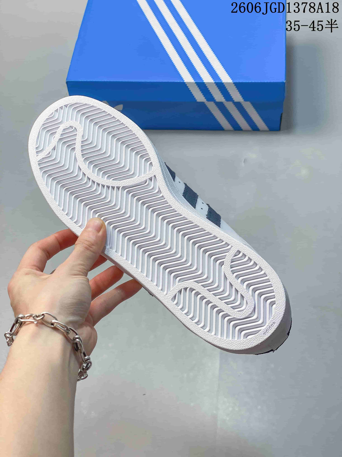 Underside of a white sneaker showing a patterned outsole; a size-range overlay reads 35–45½.